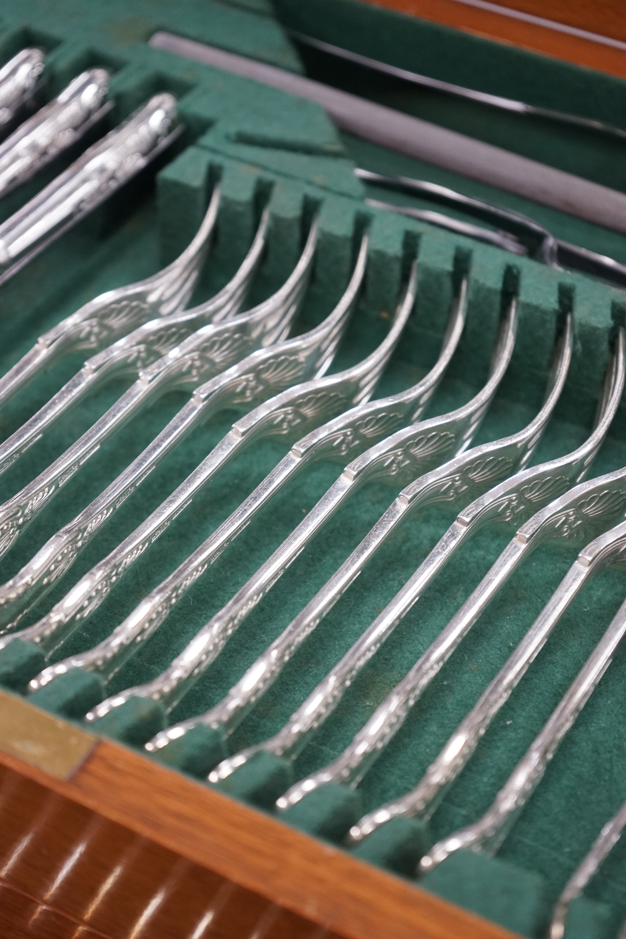 A mid 20th century canteen of Maple & Co silver plated King's pattern cutlery for twelve, comprising ninety six items, together with three odd pairs of plated sugar tongs, housed in a three drawer mahogany canteen with k